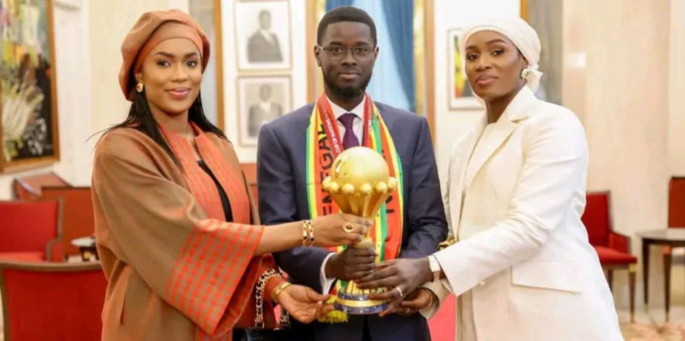 Reactions as Senegal President Faye poses with 2 wives and AFCON Trophy after Teranga Lions' victory